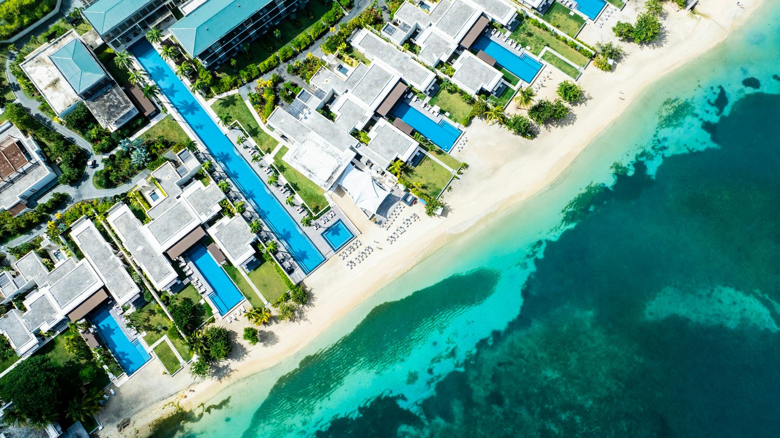 Premium aerial beach resort beside turquoise ocean in Grenada
